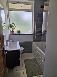 Un baño con lavabo, inodoro y ventana. en Bright Spacious Airy 2 Bed Flat, en Ealing