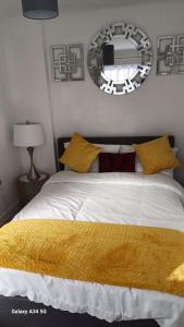 a bedroom with a bed with a yellow blanket on it at Newly built home away from home in Peterborough