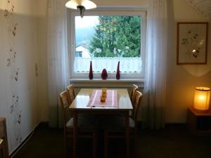 mesa de comedor con sillas y ventana en Haus Vier Jahreszeiten en Altenau