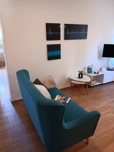 a living room with a blue couch and a table at Apartman Suzy in Pula