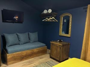 a blue room with a couch and a mirror at Fole Guest House in Pogradec