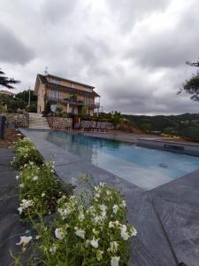 a house with a swimming pool in front of a house at Podere Belvedere in Moneglia