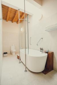 a white bathroom with a tub and a toilet at Hotel Azul de Oaxaca in Oaxaca City +59 photos