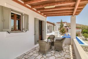 patio con sedie in vimini e pergolato in legno di Villa Manios Glisidia sea view a Kampos Paros