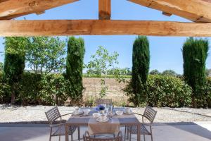 a table and chairs in a patio with a view of a field at Resort Capalbio in Capalbio