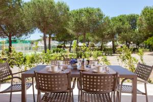 a table with four chairs and a table with cups at Resort Capalbio in Capalbio
