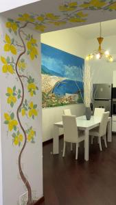 a dining room with a table and a tree mural at I 7 MARI home in Salerno
