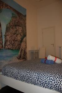a bedroom with a bed with a painting on the wall at I 7 MARI home in Salerno