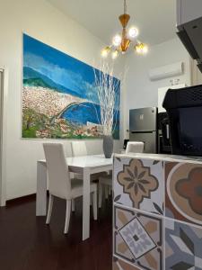 a dining room with a white table and chairs at I 7 MARI home in Salerno