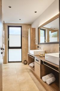 een badkamer met twee wastafels en een grote spiegel bij Stilvolle Luxuswohnung in der Residenz Silvretta in See