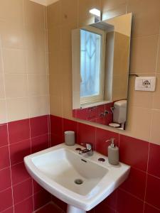 a bathroom with a white sink and a mirror at Villa Nobile in Siracusa +8 photos