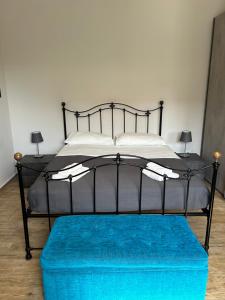 a black bed with a blue ottoman in a room at Villa Nobile in Siracusa