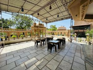 a patio with tables and chairs and a building at Hotel Empire Palace in Udaipur