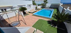 a swimming pool on a building with chairs around it at Direktly at our Swimming pool - Relax - Aduls only in Tías