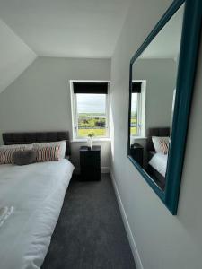 una camera con specchio, letto e divano di Bobbys Studio a Belmullet