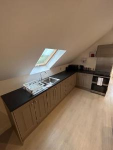 una cucina mansardata con lavandino e piano cottura di Bobbys Studio a Belmullet