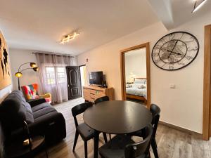 a living room with a table and a clock on the wall at Casa da Ribeira in Vila do Bispo