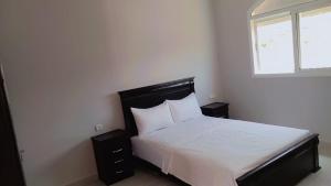 a bedroom with a bed with white sheets and a window at Ayya in Tangier +4 photos