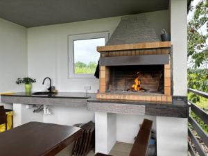 a kitchen with a stone fireplace in a house at Sweet Hideout Filovci in Filovci
