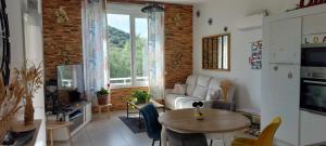 a living room with a couch and a table at Maison t3 duplex avec jacuzzi in Bastelicaccia