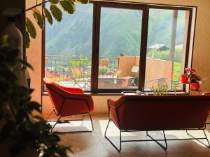 a room with a table and chairs and a view of a balcony at Apartment Nikolo in Kazbegi