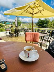 a cup of coffee sitting on a wooden table at Gazdinstvo Popovic,Kucka Korita-Podgorica in Podgorica