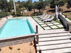 - une piscine avec chaises longues à côté d'une villa dans l'établissement Appartamento Puccini, à Fasano