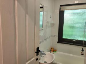 a white bathroom with a sink and a window at Bumbeldink in Uny Lelant +65 photos