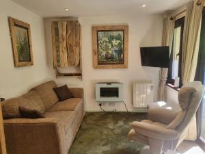 a living room with a couch and a tv at Bumbeldink in Uny Lelant