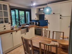 a kitchen with a wooden table and a dining room at Bumbeldink in Uny Lelant