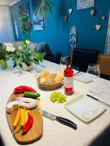 a table with a cutting board with vegetables and a bottle of wine at Appartments - Stromberg & Zabergäu in Erligheim