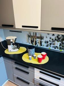 a kitchen counter with two cups on yellow plates at Appartments - Stromberg & Zabergäu in Erligheim +26 photos