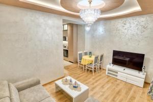 a living room with a couch and a tv and a table at Apartments Elena in Budva