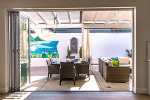 a patio with a table and chairs and a couch at Upscale Beach Cottage a Block to the Beach Sauna in Encinitas