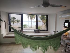 a hammock in a room with a view of the ocean at Habitación de lujo en hermosa casa frente al mar in Cartagena de Indias
