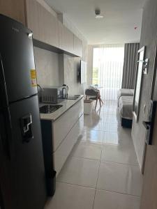 a kitchen with a stove and a refrigerator in it at Loft en frente de la playa, Bello Horizonte in Santa Marta