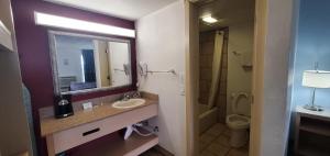 un bagno con lavandino, specchio e WC di Super 8 by Wyndham City of Moore a Moore Altre 19 foto