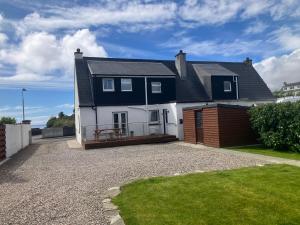 a black and white house with a gravel driveway at Salmon House in Stornoway
