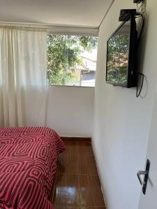una camera da letto con un letto rosso e una finestra di Pouso de Teria a Tiradentes