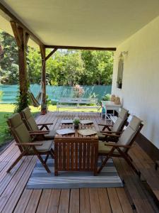 a patio with a table and chairs on a wooden deck at Gesztenyeház guest house with hot tub in Leányfalu