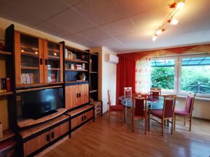 a living room with a dining table and a television at Haus Am Ölberg in Karsau