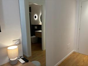 una camera con scrivania, lampada e specchio di Robely rooms ad Alghero