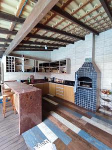 a large kitchen with a counter and an oven at Edícula acolhedora in Serra