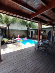 a deck with a pool with a table and chairs at Edícula acolhedora in Serra +6 photos