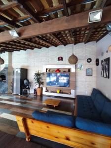 a living room with a blue couch and a tv at Edícula acolhedora in Serra