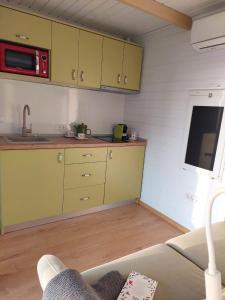 a kitchen with yellow cabinets and a sink at Fancy Maisonnette in Gura Humorului