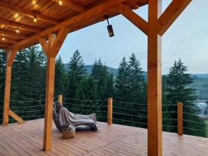 a hammock on a deck with a view of the mountains at Fancy Maisonnette in Gura Humorului