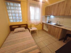 a small room with a bed and a kitchen at Niki's house 2 in Agia Triada