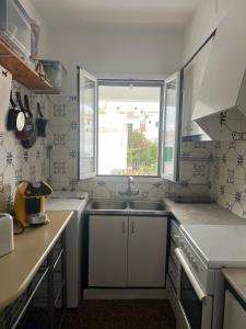 a small kitchen with a sink and a window at Es Grau Lamorino in Es Grau +36 photos