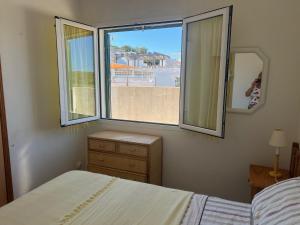 a bedroom with a bed and a window with a view at Es Grau Lamorino in Es Grau